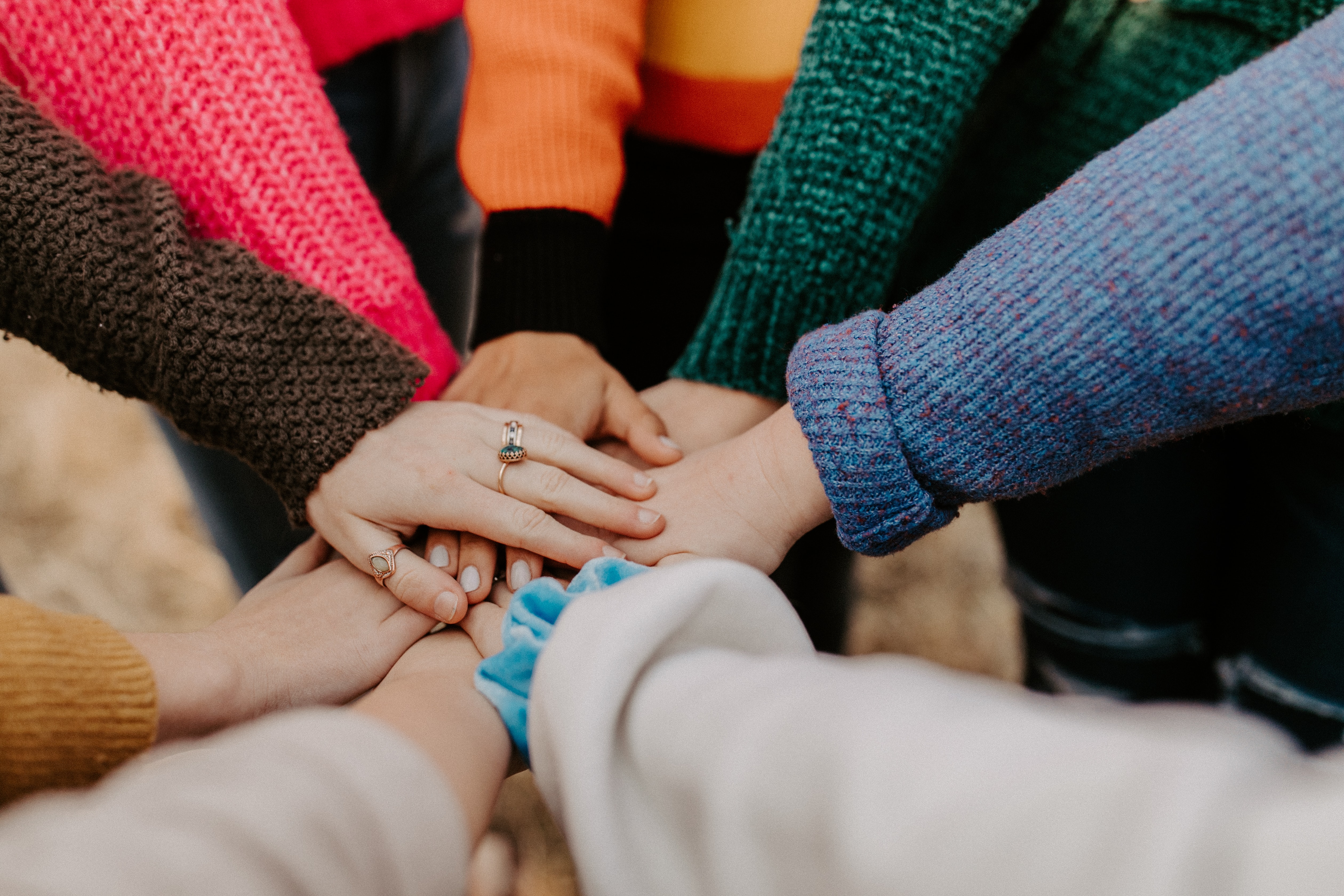 team building image of people seeming to have a common goal with hands in a pile