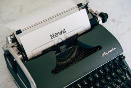 typewriter with paper that says news